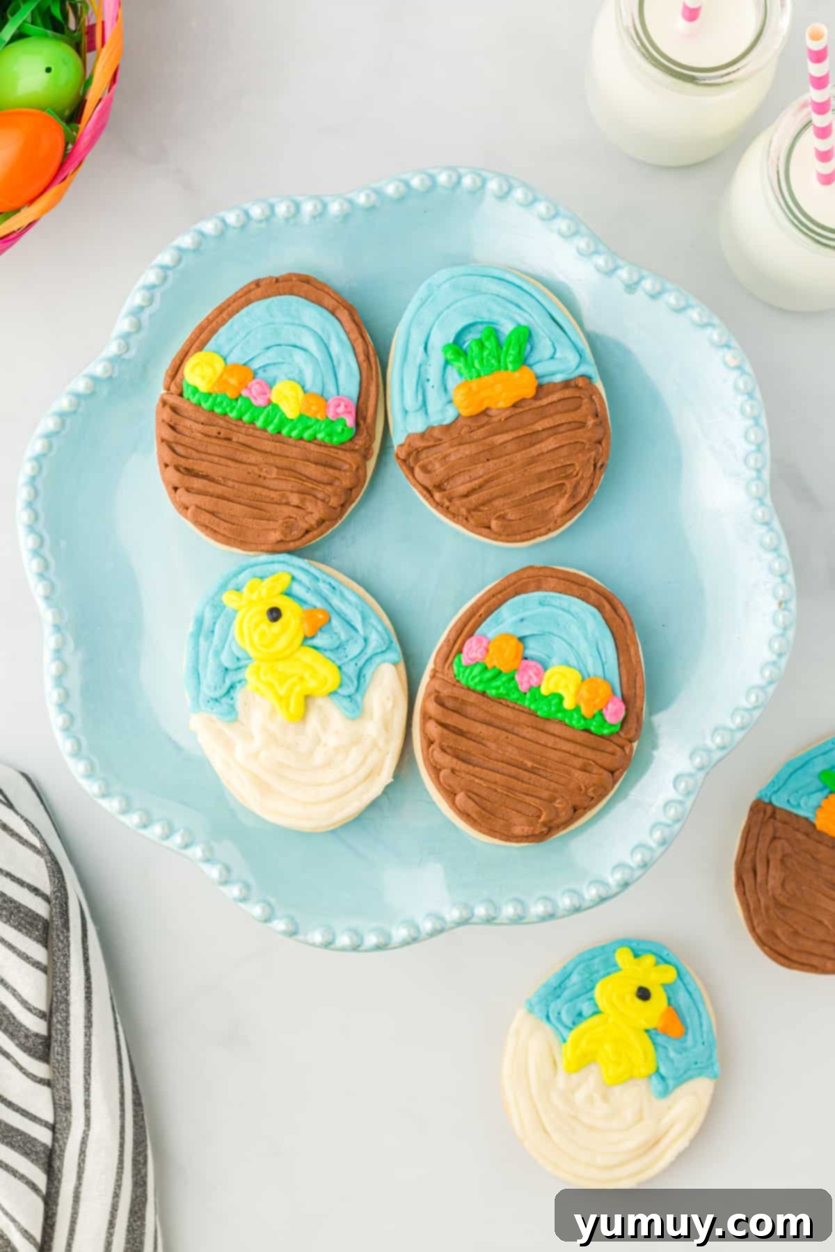 Whimsical Easter Egg Cookies 2 Four beautifully decorated Easter egg sugar cookies arranged on a blue plate, viewed from above.