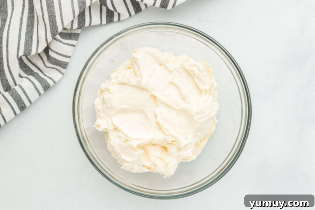 Whimsical Easter Egg Cookies 16 Overhead view of fluffy buttercream frosting in a glass bowl, perfectly mixed and ready for coloring.