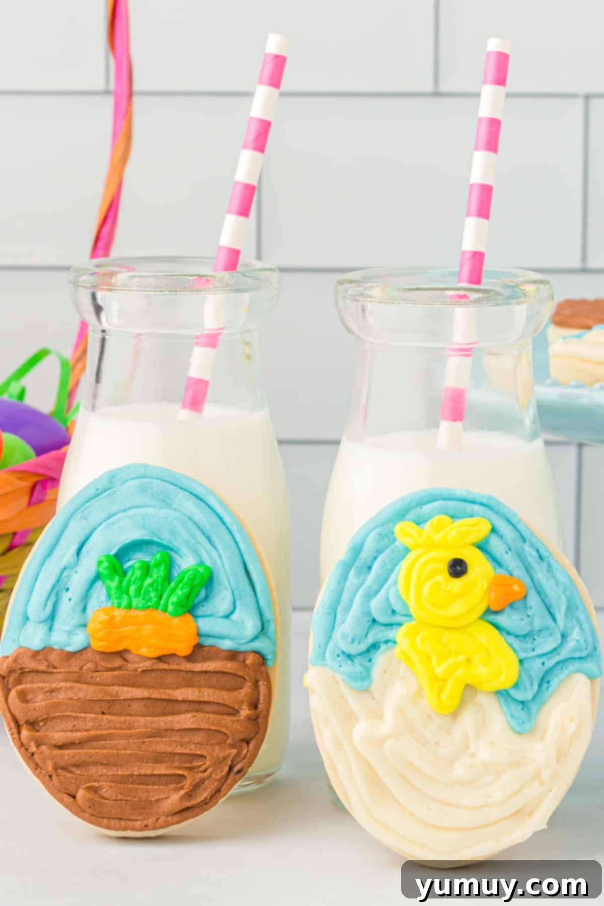 Whimsical Easter Egg Cookies 3 Close-up of two frosted Easter egg sugar cookies leaning against glasses of milk with pink and white straws, highlighting their intricate decorations.