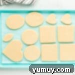 Whimsical Easter Egg Cookies 8 Overhead view of cut-out Easter egg sugar cookies arranged on a blue baking sheet, ready for chilling.