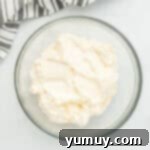 Whimsical Easter Egg Cookies 9 Overhead view of fluffy frosting for Easter egg sugar cookies in a glass bowl.