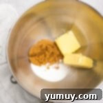 overhead view of butter and sugars for easter basket cookie cups in a stainless mixing bowl.