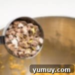 crushed cadbury mini eggs added to easter basket cookie cup dough in a stainless mixing bowl.