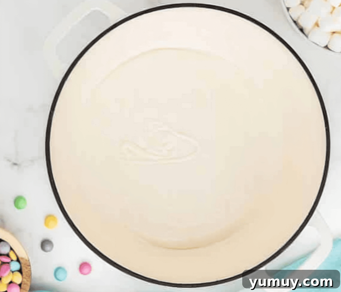 Spring Crispy Delights 6 Melted marshmallows in a Dutch oven with a silicone spatula.