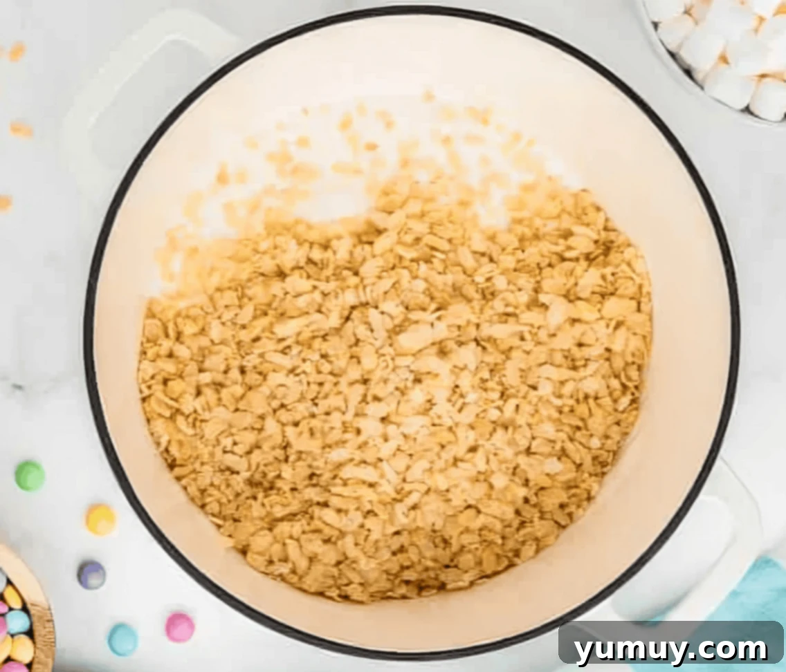 Spring Crispy Delights 7 Rice Krispie cereal being poured over melted marshmallows in a Dutch oven.