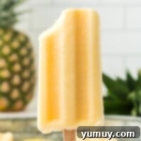 Two homemade Dole Whip popsicles, a refreshing frozen dessert.