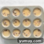 Luscious Blackberry Cupcakes 8 A cupcake tin with liners filled with blackberry cupcake batter, ready for baking.