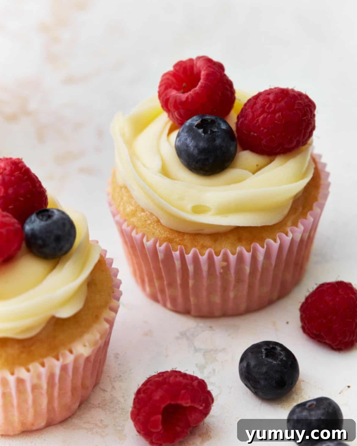 Frosted berry cupcakes artfully arranged and garnished with fresh berries, highlighting their vibrant appeal.