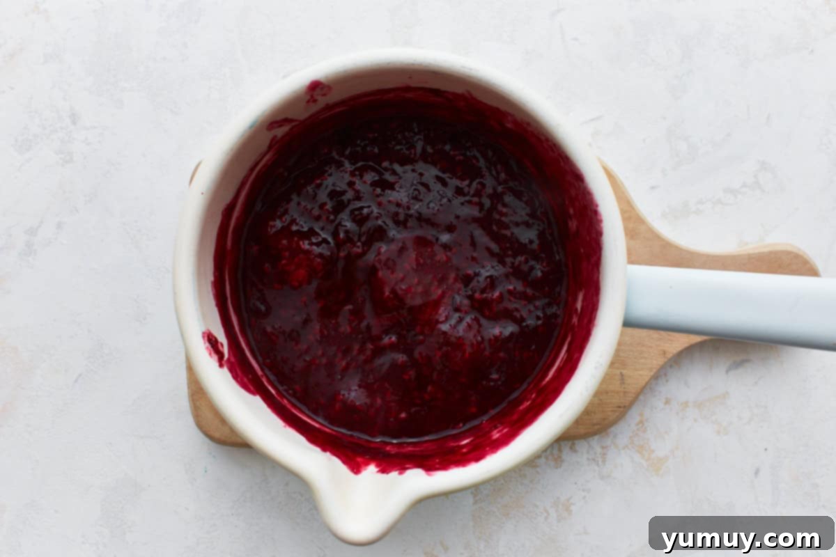 Thickened berry filling simmering in a saucepan, showcasing its rich color and texture.