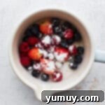 Fresh berries and sugar in a saucepan.