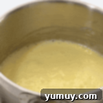 Boston Cream Delights 12 Thick, bubbling pastry cream simmering in a saucepan.