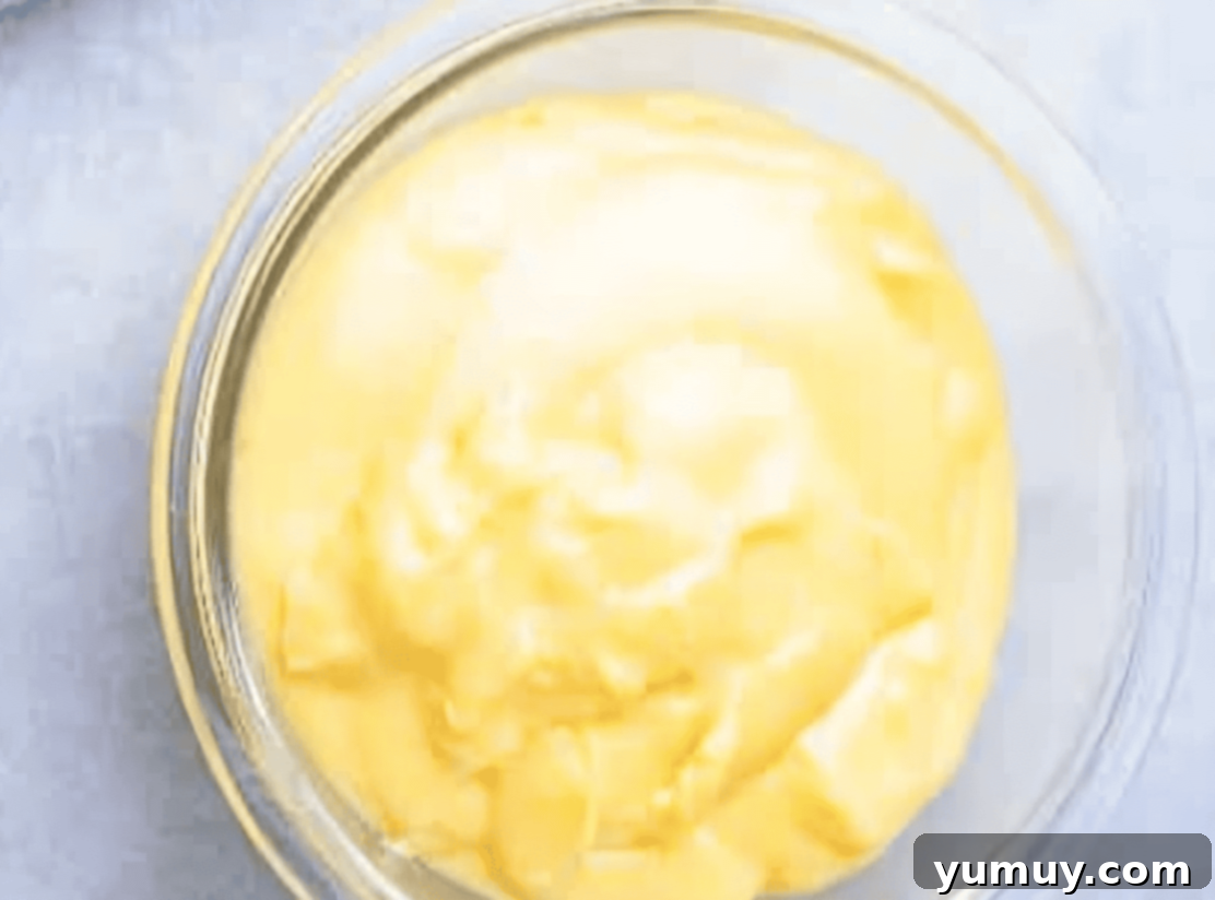 Boston Cream Delights 24 Smooth vanilla pastry cream, covered with plastic wrap, chilling in a glass bowl.