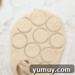 Boston Cream Delights 9 Donut dough being cut into perfect rounds with a cookie cutter.