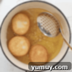 Boston Cream Delights 10 Golden-brown donuts frying in hot oil in a Dutch oven.