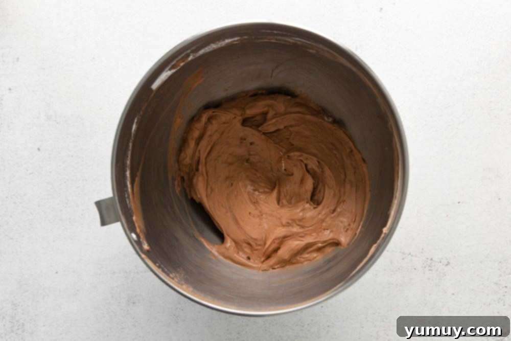 no bake chocolate cheesecake batter in a stainless mixing bowl.