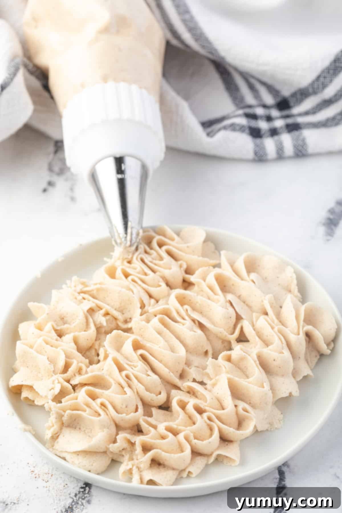 Caramelized Brown Sugar Buttercream 3 cinnamon brown sugar buttercream frosting piped onto a plate