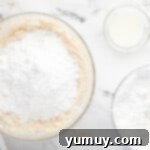 Caramelized Brown Sugar Buttercream 6 a bowl of flour, sugar, and other ingredients on a marble countertop.