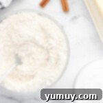 a bowl of flour, sugar and cinnamon next to a spoon.