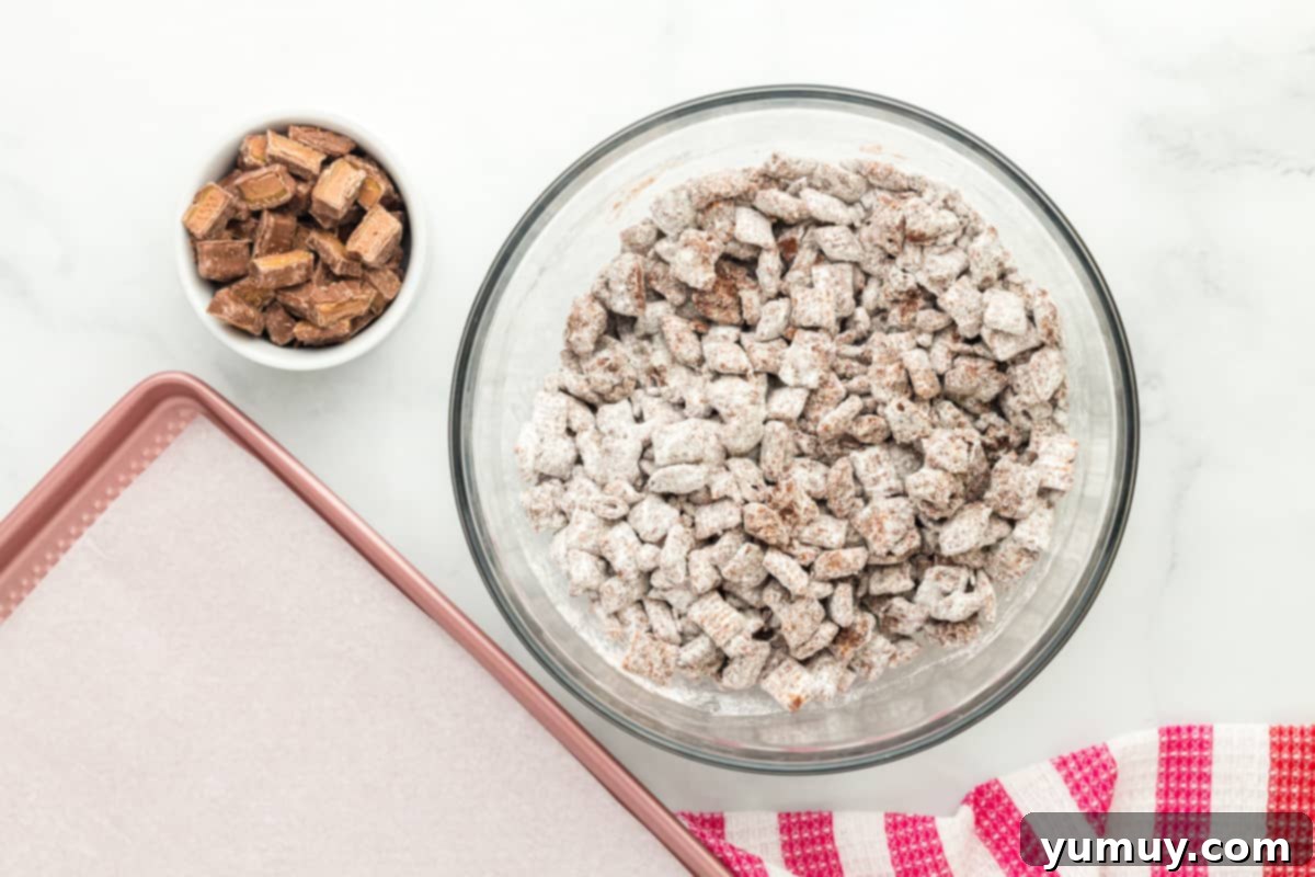 a bowl of chocolate caramel puppy chow coated in powdered sugar