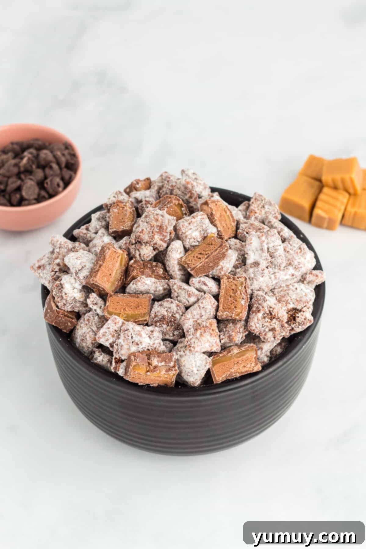 a bowl of puppy chow with chocolate caramel candies