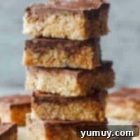 Stacked scotcheroos with the top one showing a bite missing.