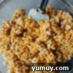 A bowl of Rice Krispies cereal being coated with the peanut butter mixture.