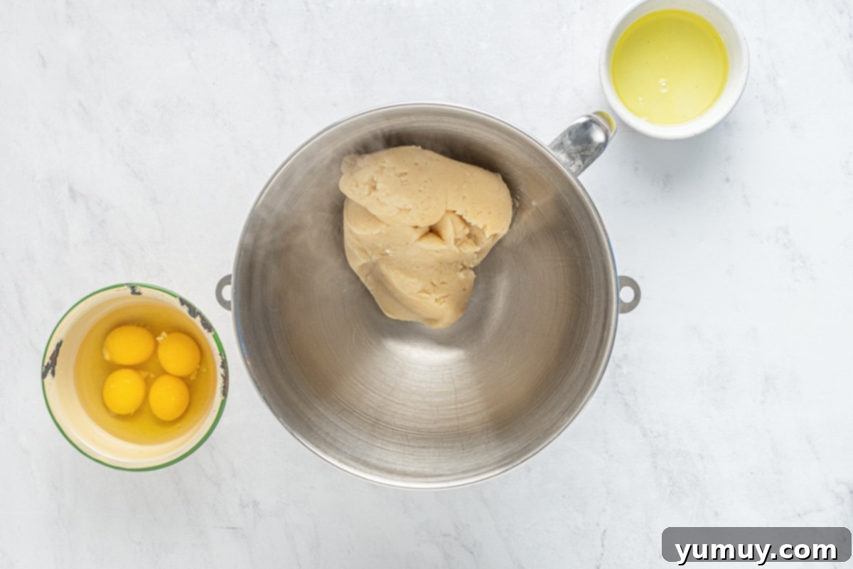 The choux pastry dough cooling in a stand mixer, with eggs and butter waiting to be added.