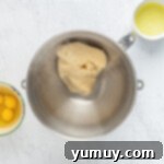 Bowl with choux pastry ingredients, including eggs, flour, and butter, waiting to be mixed.