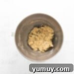 Golden Oat Raisin Delights 6 Oatmeal raisin cookie dough in a mixing bowl on a white background, ready for baking.