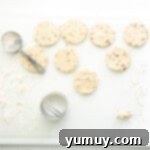 Melt-in-Your-Mouth Pecan Shortbread 4 cut out pecan shortbread cookies on a floured cutting board.