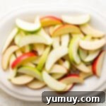 A vibrant mix of green and red apple slices, perfectly prepared and ready for topping.