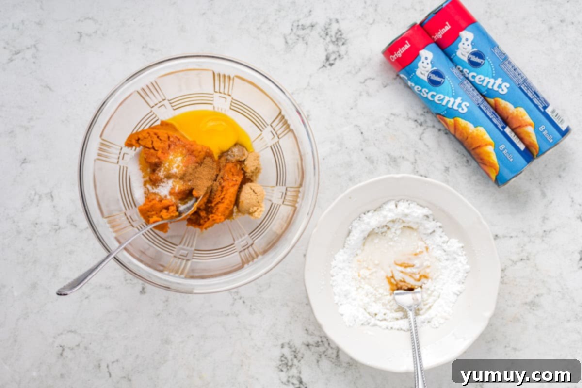 A mixing bowl filled with wet ingredients for pumpkin filling, with dry ingredients and crescent roll cans in the background.