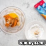 A mixing bowl filled with wet ingredients for the pumpkin filling.