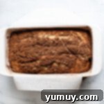 Snickerdoodle Swirl Bread 10 A beautifully baked loaf of cinnamon bread in a baking dish, ready to be cooled.