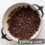 Irresistible Homemade Crunch Bars 5 Chocolate chips and melted butter in a Dutch oven, being stirred.