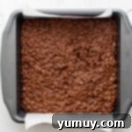 Irresistible Homemade Crunch Bars 7 Homemade crunch bar mix spread evenly in an 8x8 baking pan.