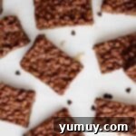 Irresistible Homemade Crunch Bars 8 Overhead view of homemade crunch bars cooling on a white surface.