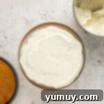 Irresistible Pumpkin Cake with Zesty Cream Cheese Frosting 11 spreading frosting onto a cake layer