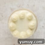 Irresistible Pumpkin Cake with Zesty Cream Cheese Frosting 12 overhead view of cake decorated with cream cheese frosting and frosting dollops