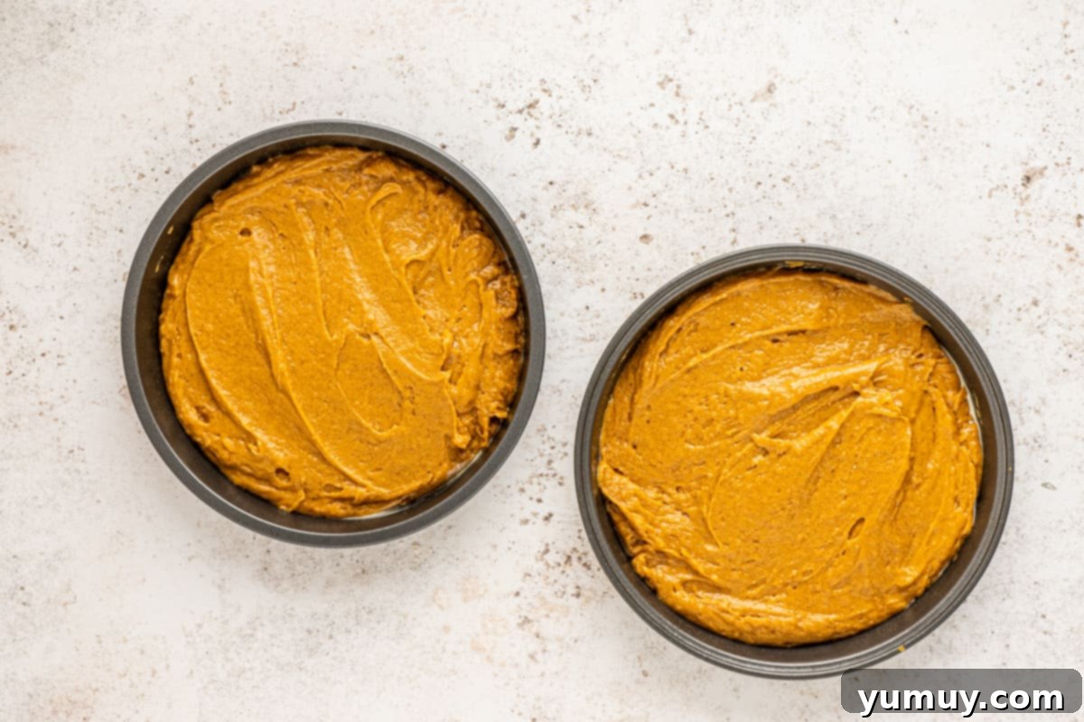 Irresistible Pumpkin Cake with Zesty Cream Cheese Frosting 14 cake batter spread into two round cake pans