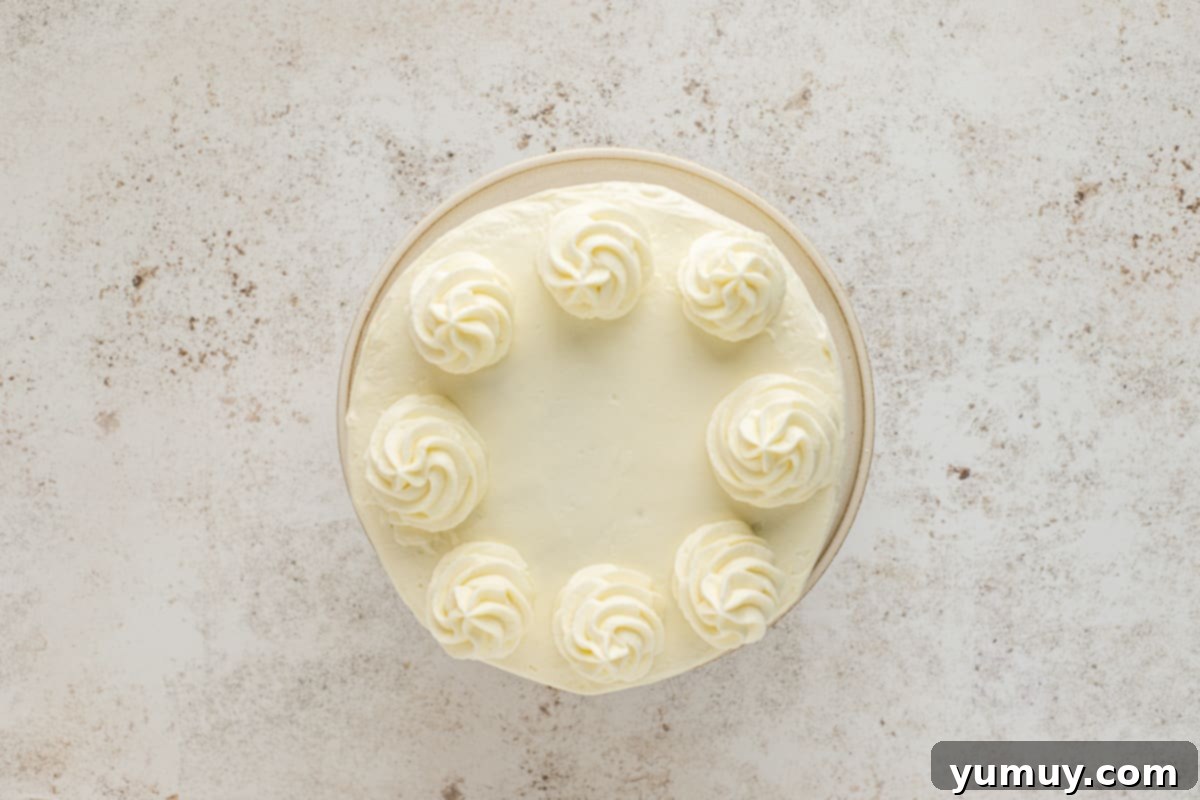 Irresistible Pumpkin Cake with Zesty Cream Cheese Frosting 20 overhead view of cake decorated with cream cheese frosting and frosting dollops