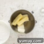 Irresistible Pumpkin Cake with Zesty Cream Cheese Frosting 8 butter and cream cheese in a mixing bowl