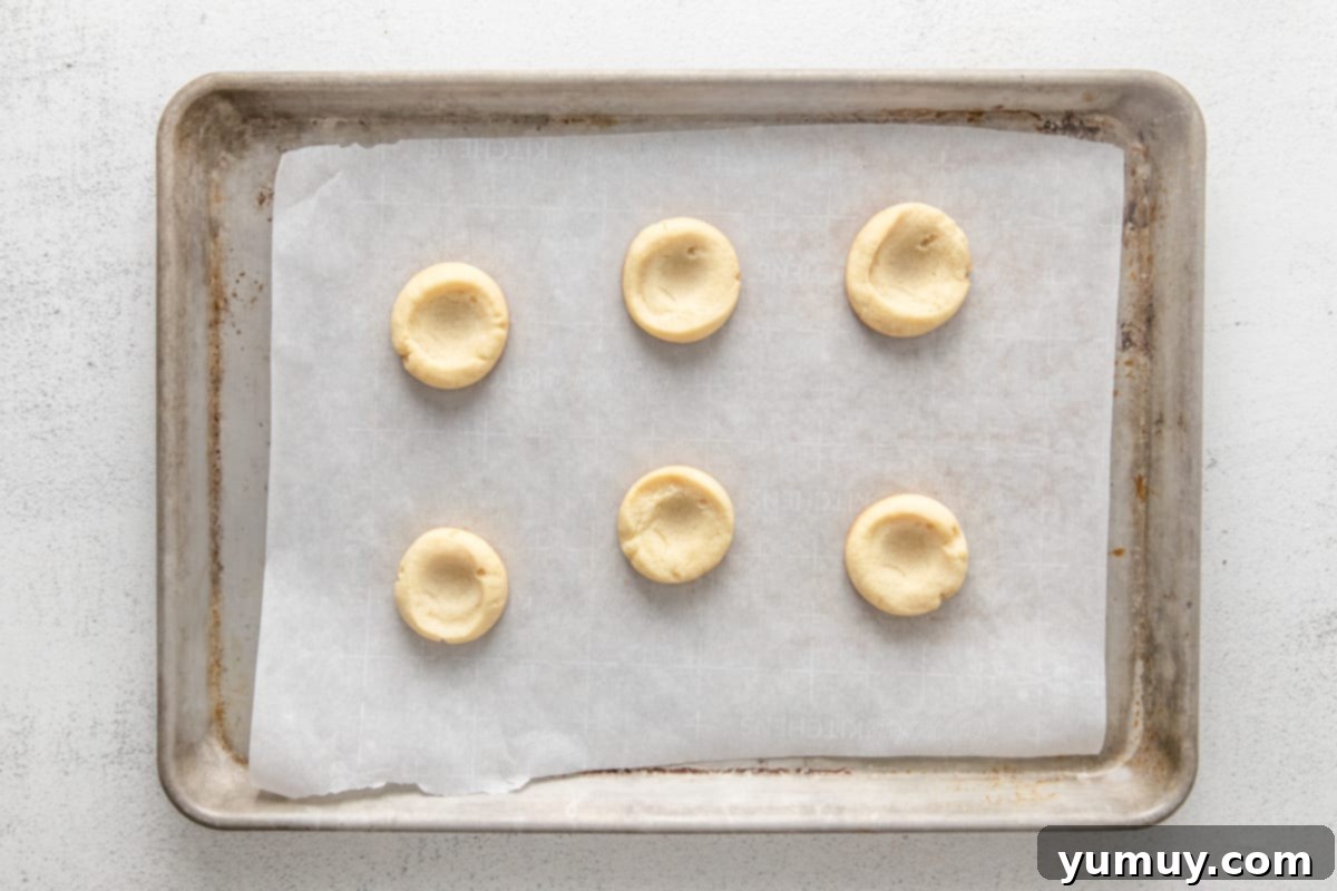 Caramel Chocolate Shortbread Cookies 16 Six baked shortbread thumbprint cookies cooling on a baking sheet, ready for their caramel filling.