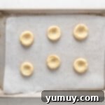 Caramel Chocolate Shortbread Cookies 9 Six baked shortbread thumbprint cookies cooling on a baking sheet.