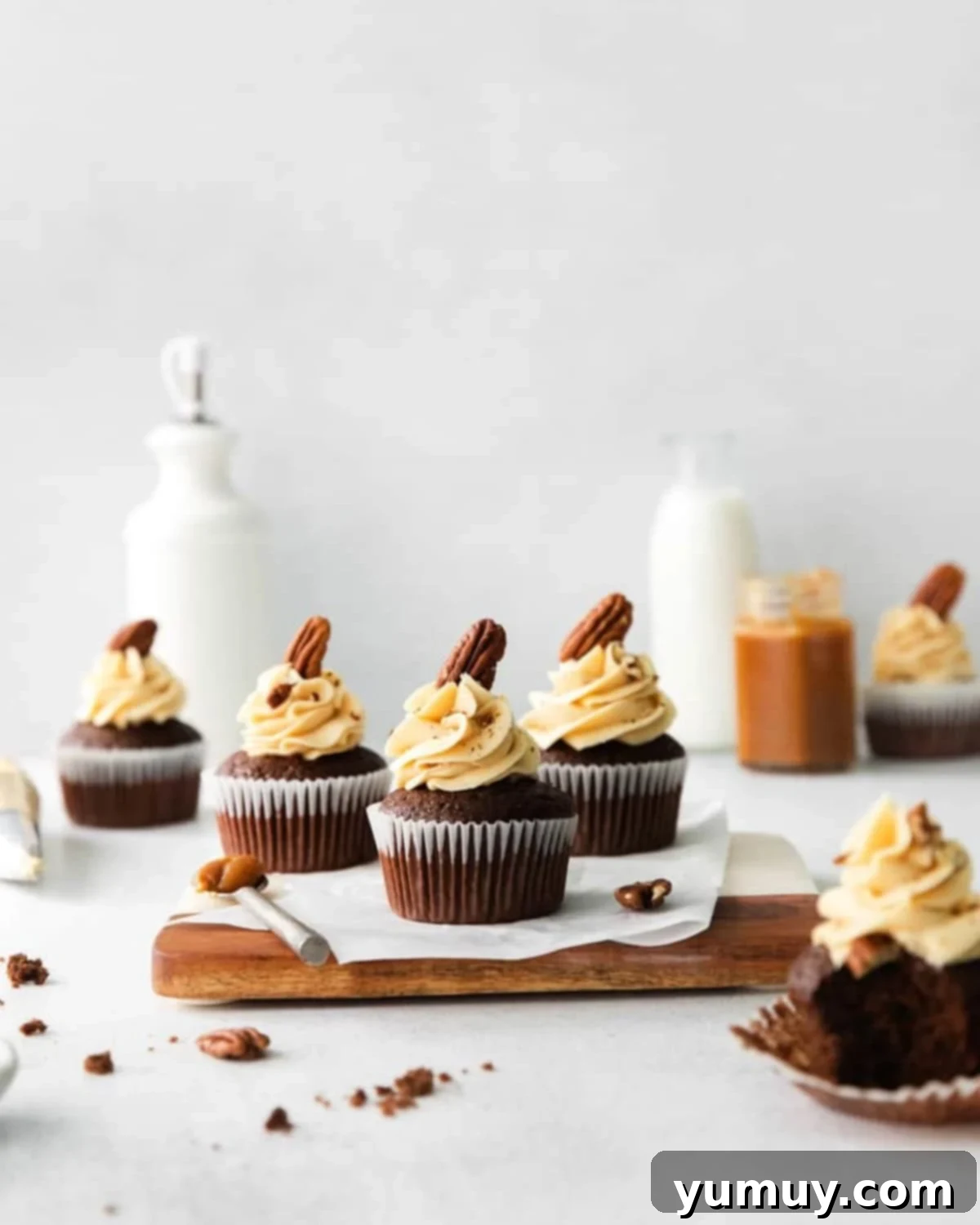 side view of a turtle cupcake on a wooden cutting board.