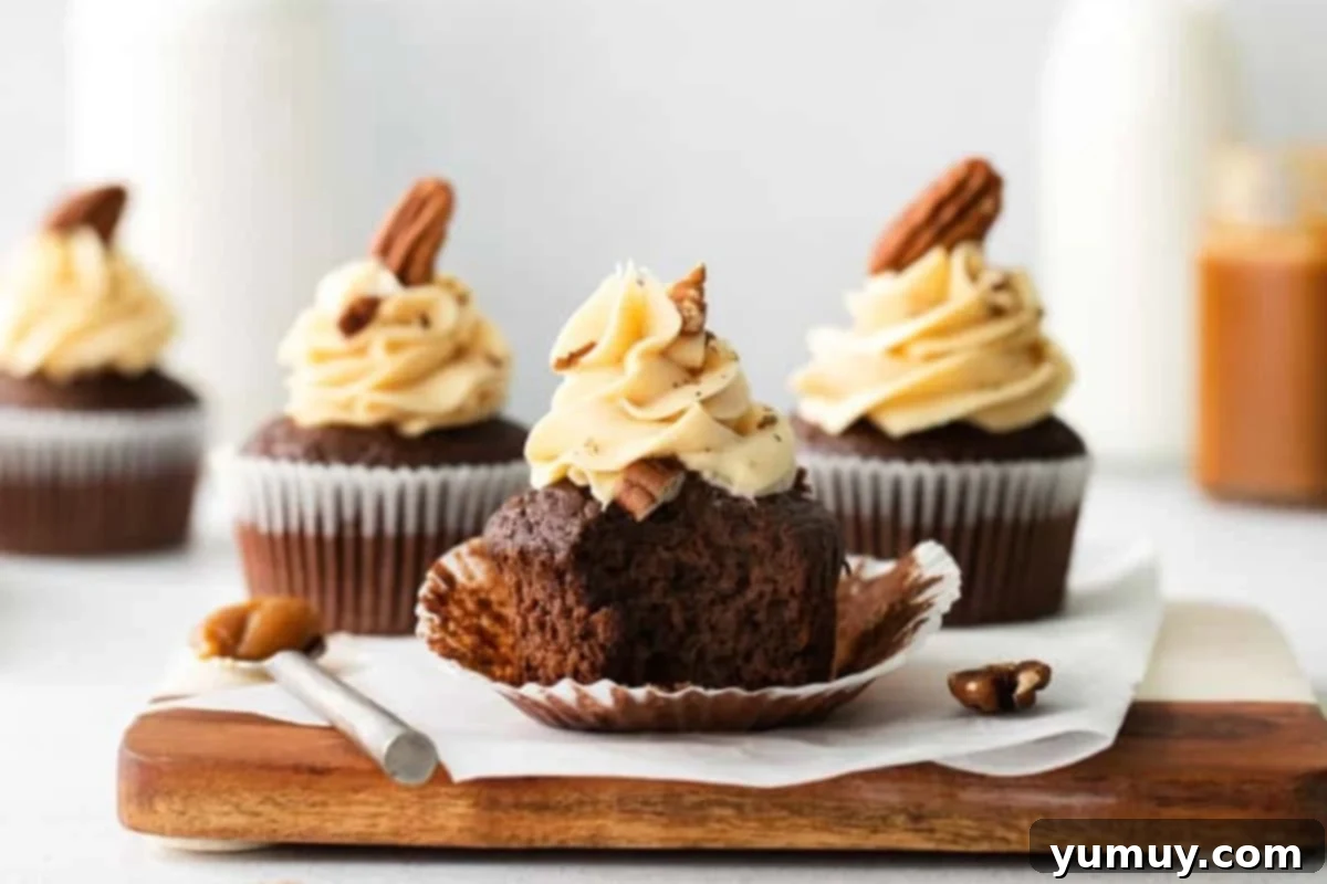 an unwrapped and bitten turtle cupcake on a wooden cutting board.