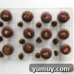 12 cored chocolate cupcakes with pecans stuffed in the middle.