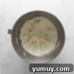 Tangy Cranberry Delights 12 Creamy frosting in a silver mixing bowl, ready for piping.