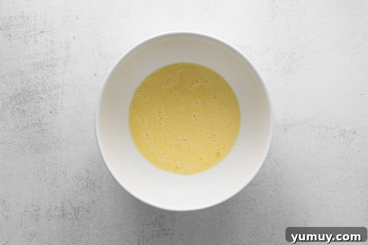 Tangy Cranberry Delights 18 Smooth, mixed wet ingredients for the cupcake batter in a large bowl.