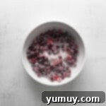 Tangy Cranberry Delights 7 A bowl of freshly sugared cranberries, sparkling and ready for use.